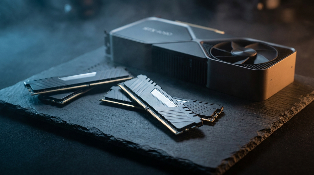 Barrettes de RAM et carte graphique sur une surface ardoise sombre