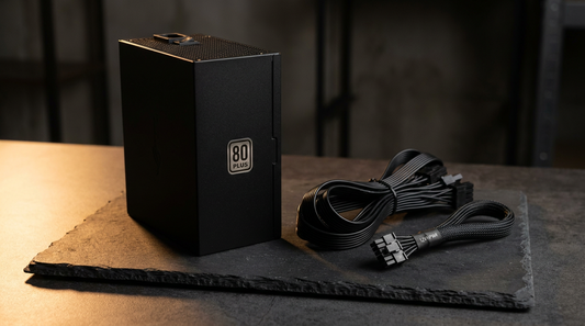 Alimentation ATX noire posée sur une surface sombre avec ses câbles modulaires et un connecteur 12V-2x6